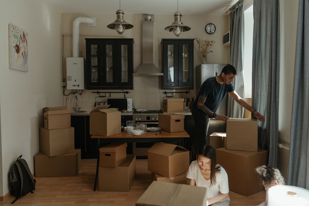 Family unpacking boxes in a cozy kitchen during home relocation.